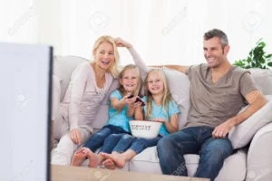 20630224-twins-and-parents-watching-television-sitting-on-a-couch-300×200